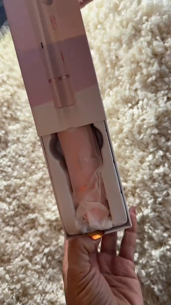 Depiladora facial portátil tipo lápiz labial sostenida en la mano